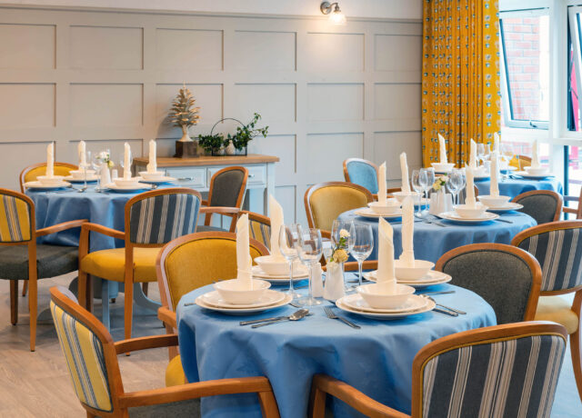 A dining room with blue table cloths